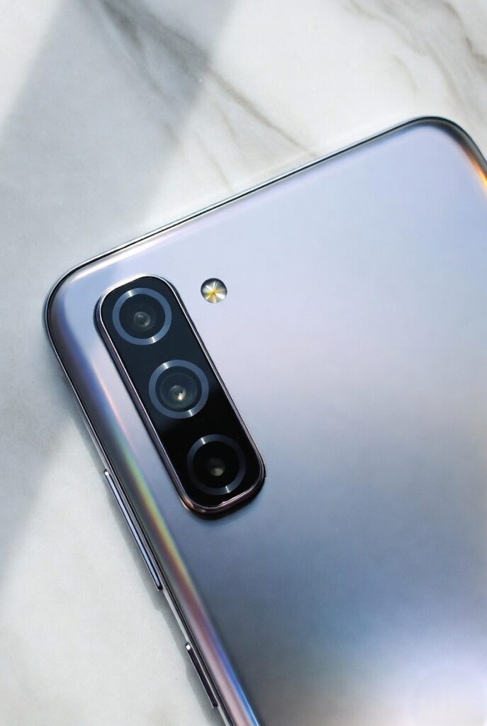 Close-up view of Samsung Galaxy M17 5G in Moonlight Silver highlighting the triple camera module with OIS-enabled 50MP main sensor and premium minimalist back design.