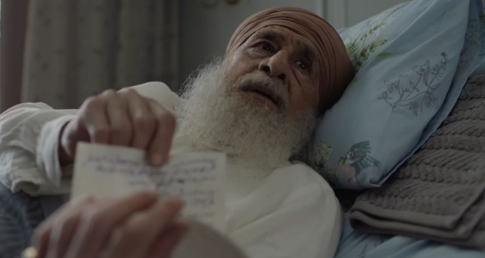 Cinematic still from Main Vaapas Aaunga showing Naseeruddin Shah as the elderly Ishar Singh Grewal in a deeply emotional deathbed scene, conveying decades of memory, longing, and the unbreakable promise central to the film’s narrative.