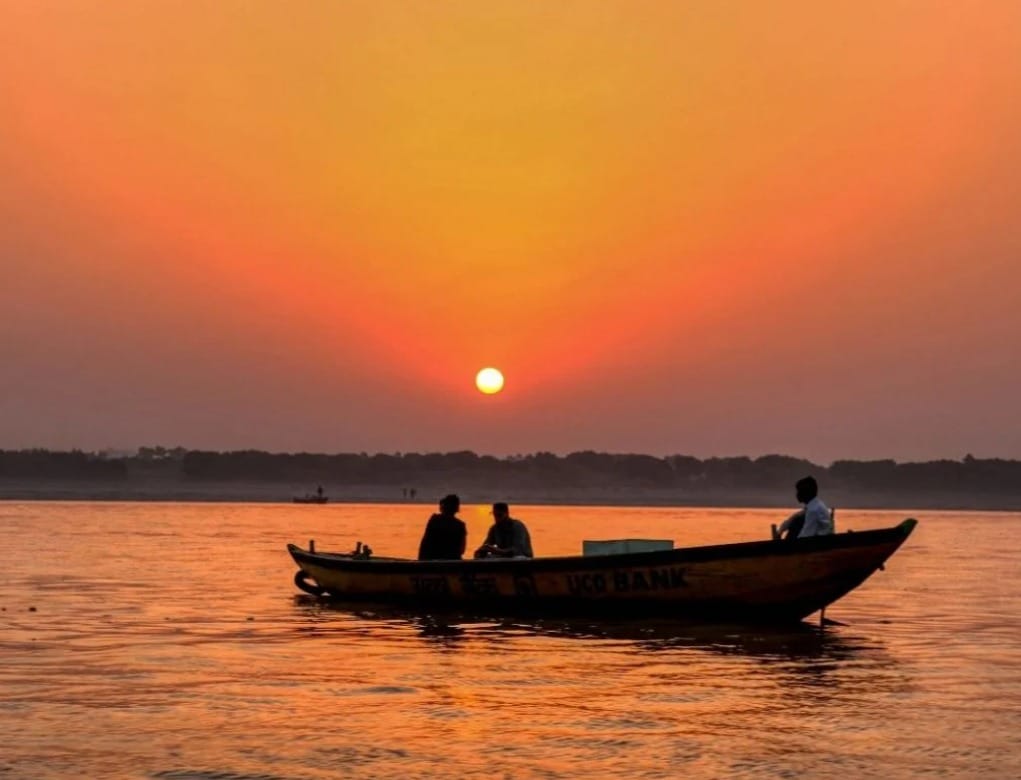 Serene boat ride at sunset on Triveni Sangam river confluence in Prayagraj, must-visit for Delhi tourists.